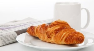 croissant newspaper and tea